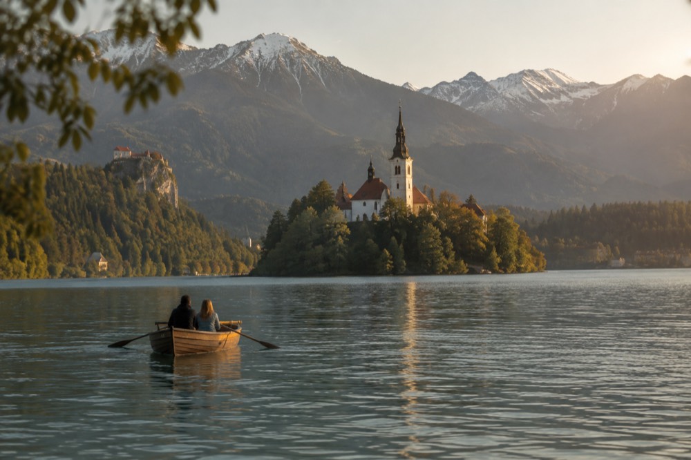 A small boat on Lake Bled with the island church in the distance