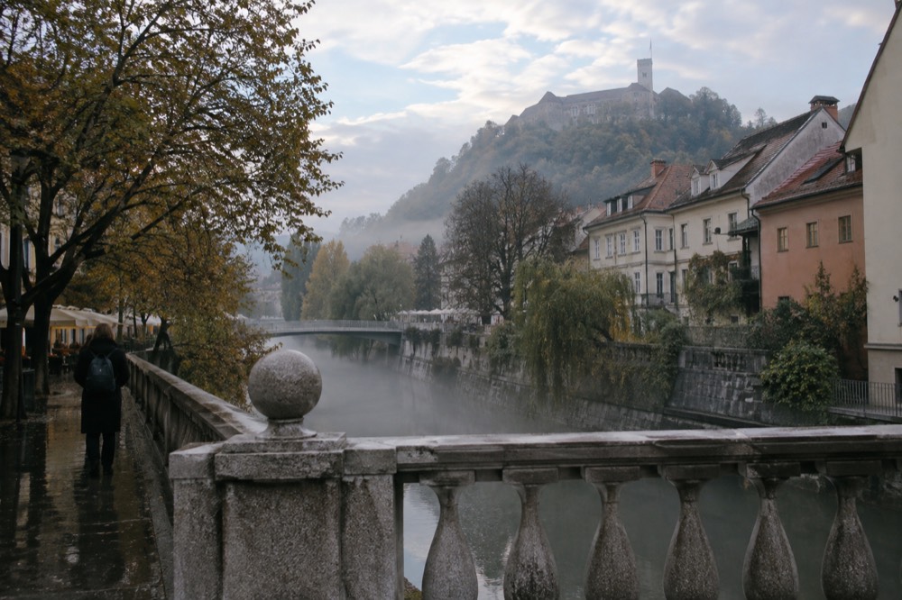 Morning mist over the Ljubljanica river with the castle hill behind