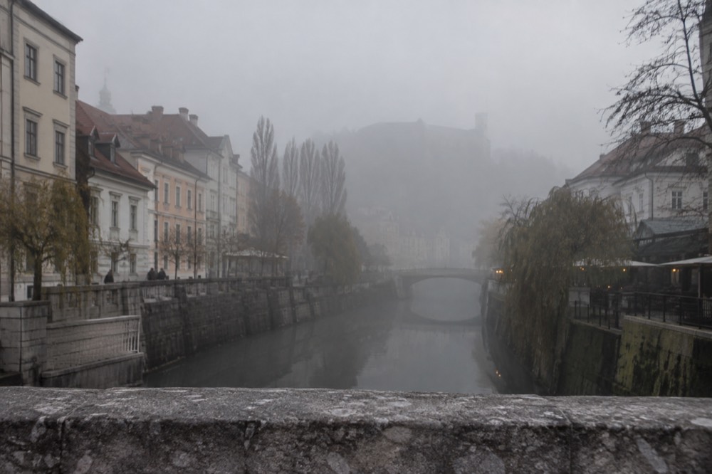 Morning fog lying over the Ljubljanica river and the city's rooftops