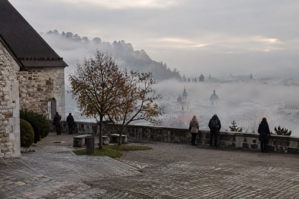 Morning fog over the rooftops of Ljubljana with the castle hill rising above the mist