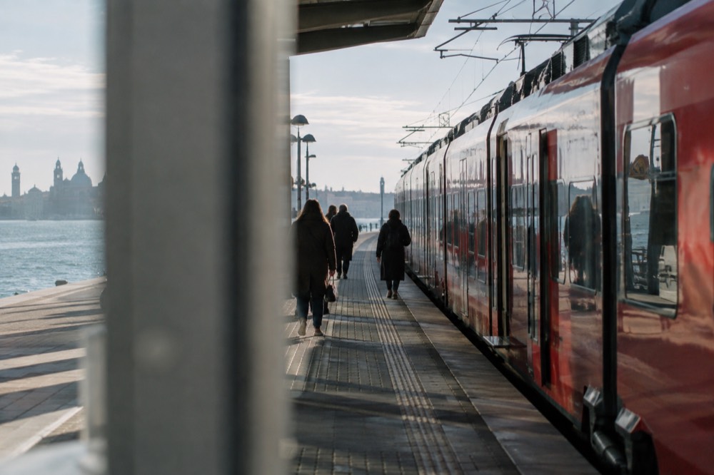 A red regional train standing at a platform in a Slovenian railway station