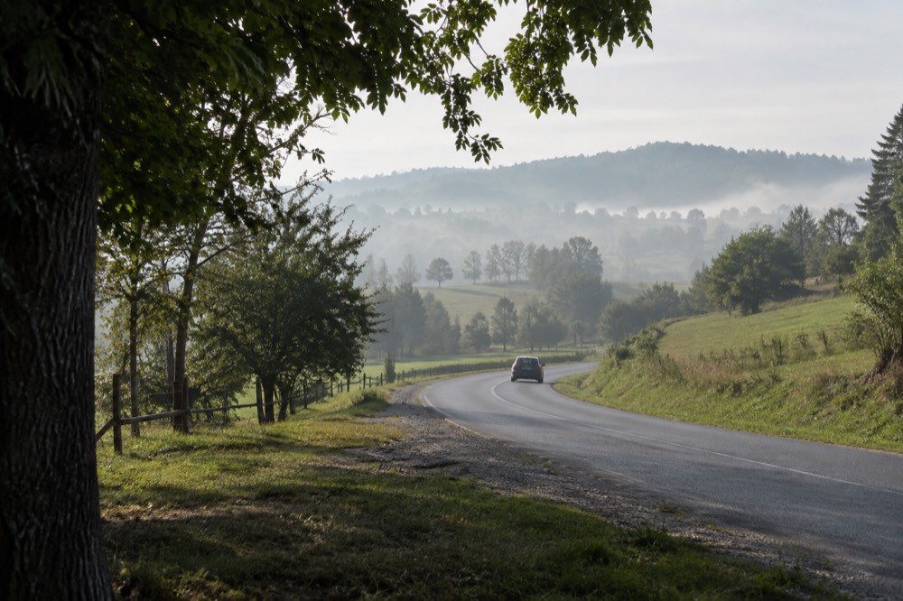 Open road crossing a green rural landscape near a national border in central Europe