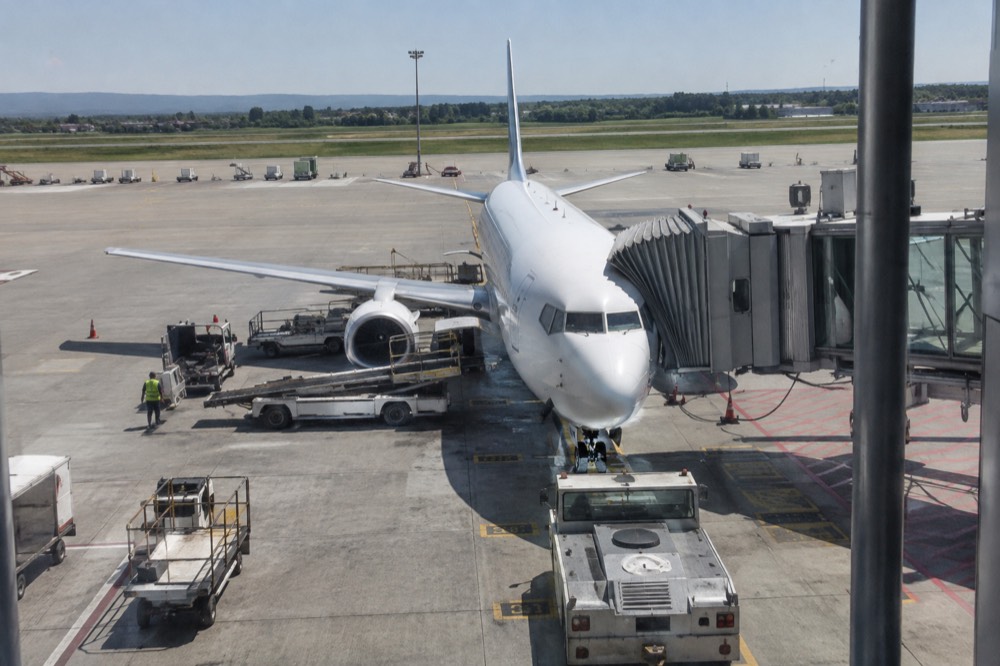 Airplane parked at an airport terminal gate under a clear sky