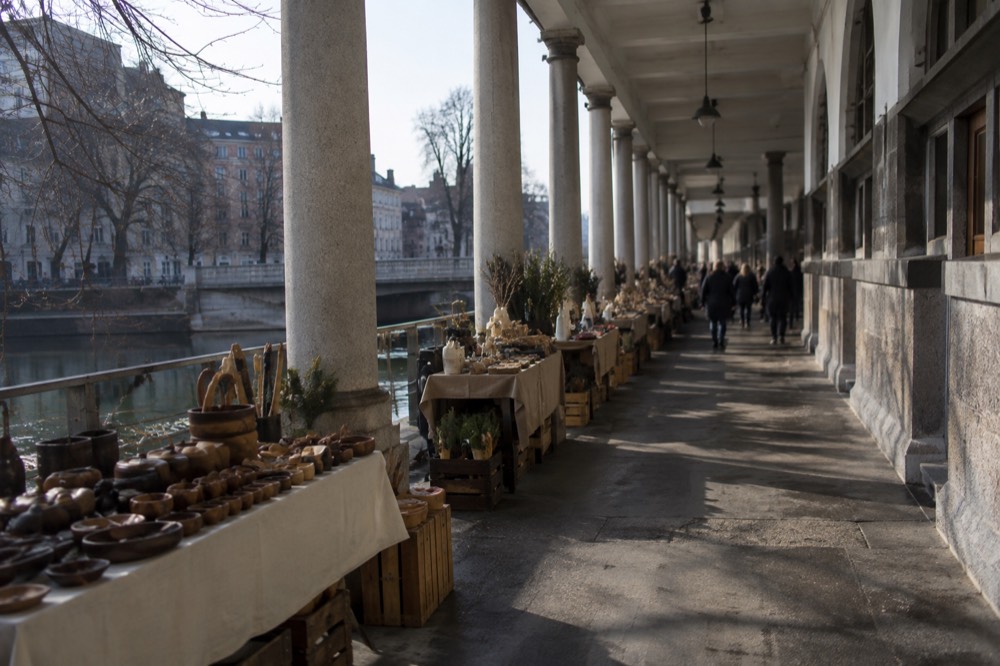 Row of market stalls under the colonnade beside the Ljubljanica in Ljubljana