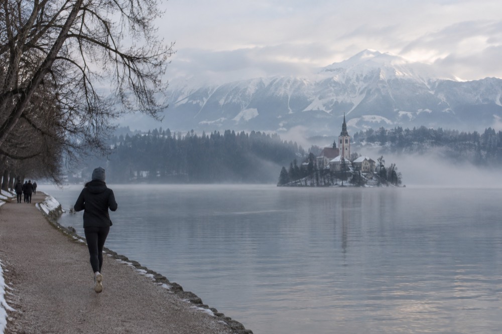Lake Bled in winter with low mist over the water and snow on the far hills
