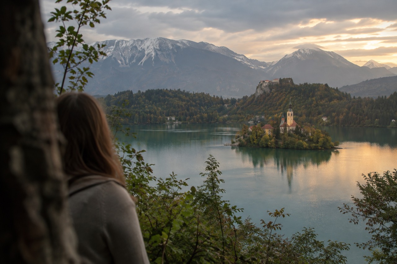 Lake Bled with the island church and forested shore at golden hour