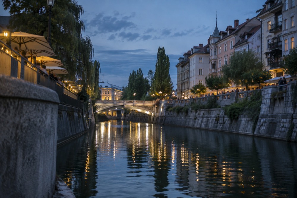 Evening light on the Ljubljanica with restaurant terraces along the embankment