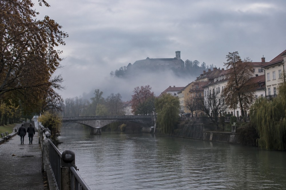 Fog resting over a river city with a hilltop castle above the mist