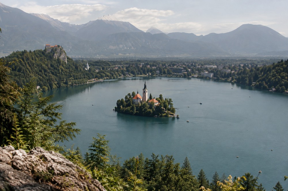 Bled Island church on the lake with Bled Castle on the cliff above
