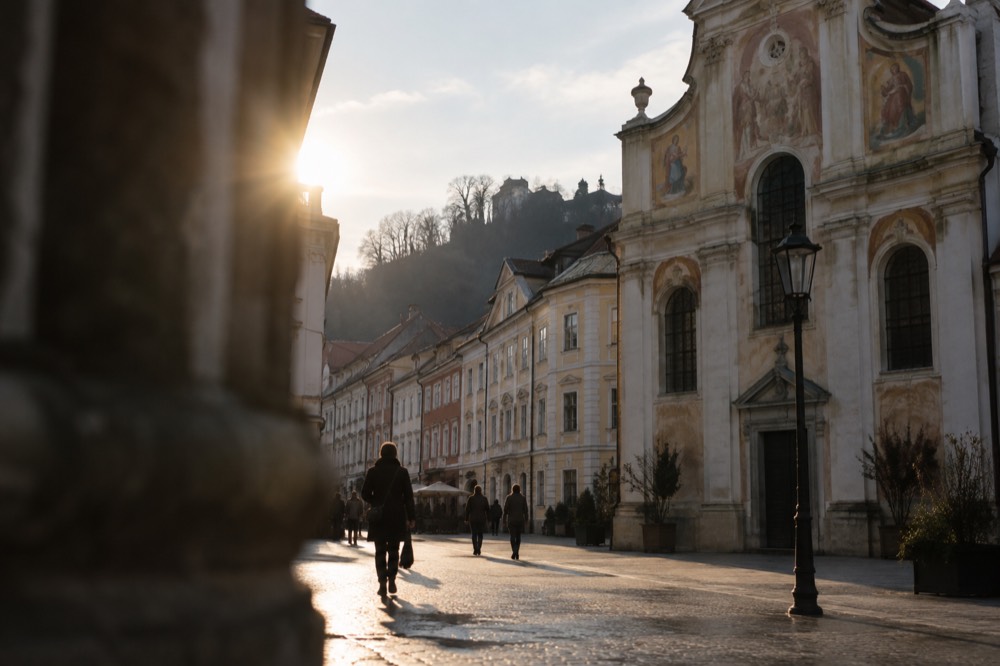 Frescoed church facade above a pedestrian square in Ljubljana