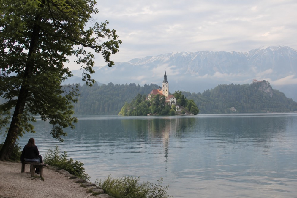 Lake Bled under light mist with the island church and forested shore