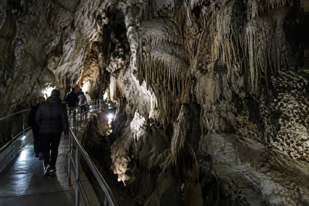 The illuminated interior passage of a large limestone cave with walkways
