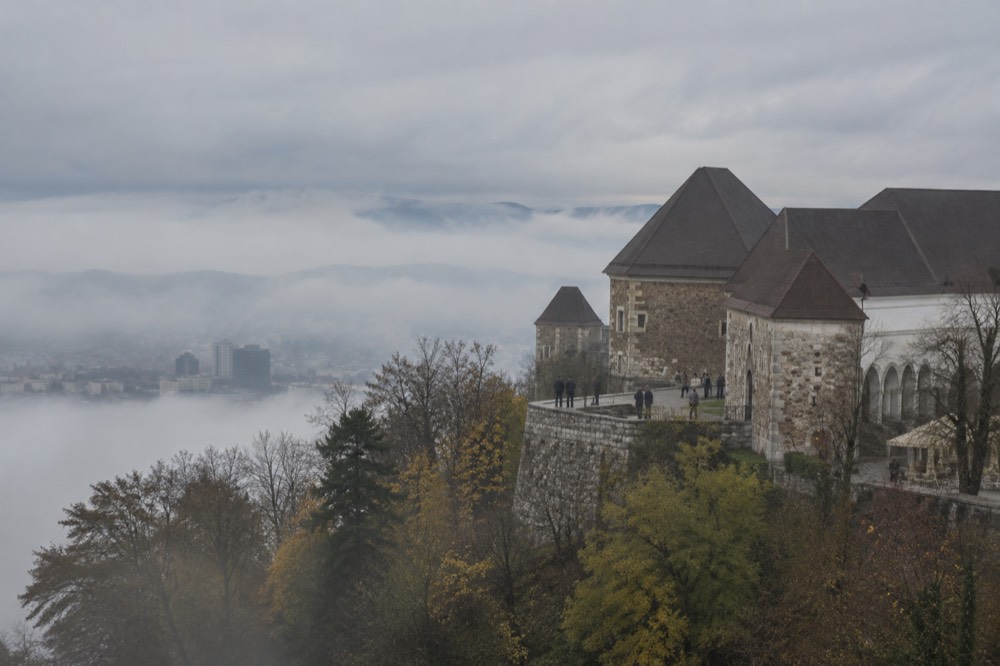 Morning fog filling the Ljubljana basin with the castle hill rising above it